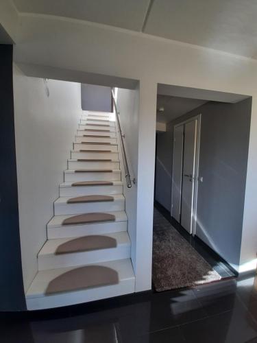 a stairway in a building with white walls and white stairs at Päikeseline Apartment WITH SAUNA in Kuressaare