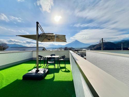 a table and chairs on a balcony with green grass at NewOpen大石100A広い展望台, 富士山と河口湖を望む 近大石公園 in Fujikawaguchiko