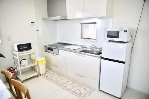 a white kitchen with a sink and a refrigerator at NewOpen大石100A広い展望台, 富士山と河口湖を望む 近大石公園 in Fujikawaguchiko