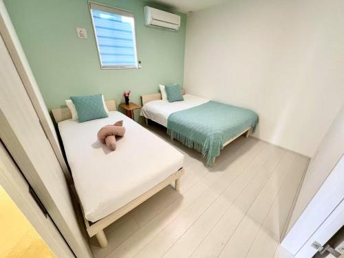 a room with two beds with a teddy bear on them at NewOpen大石100A広い展望台, 富士山と河口湖を望む 近大石公園 in Fujikawaguchiko