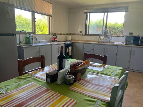 a kitchen with two tables with bottles of wine at Casa El Refugio in Santa Cruz