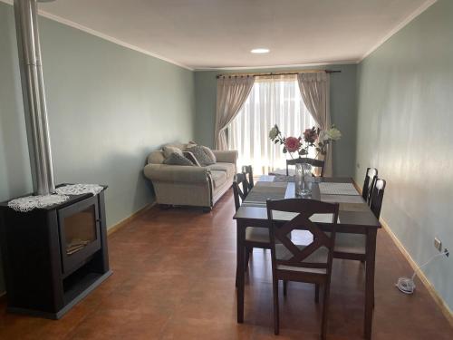 a living room with a table and a fireplace at Casa El Refugio in Santa Cruz
