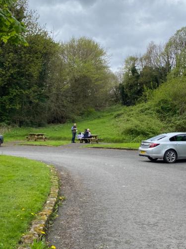 two people sitting at a picnic table on the side of a road at Seacoast View in Limavady