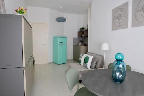eine Küche mit einem Tisch und einem grünen Kühlschrank in der Unterkunft Doma Centro 5 in Gela