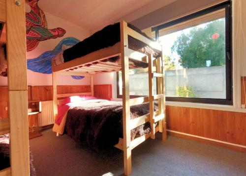 a bedroom with two bunk beds and a window at Hostal Punto Rockstar in Osorno