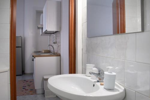 a white bathroom with a sink and a mirror at Casa Giorgia in Mesagne