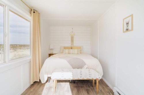 a bedroom with a bed with a bench and a window at Loma Vista By The Cohost Company in Sunfair Heights