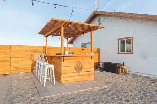 a wooden bar with a wooden roof on a patio at Loma Vista By The Cohost Company in Sunfair Heights