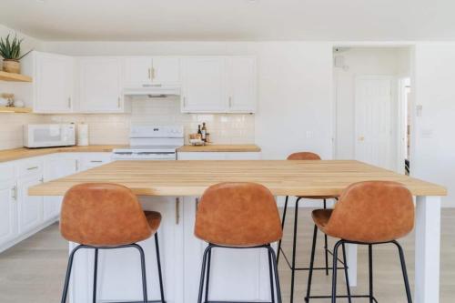 a kitchen with a wooden table and four chairs at Loma Vista By The Cohost Company in Sunfair Heights
