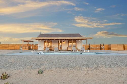 a small white house on the beach with chairs at Loma Vista By The Cohost Company in Sunfair Heights