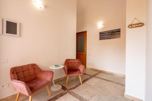 two chairs and a table in a room at Villa Bonaria Vacation Home in Capoterra
