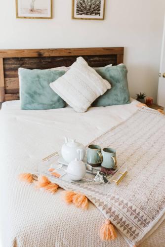 a tray with a tea set on a bed at Loma Vista By The Cohost Company in Sunfair Heights