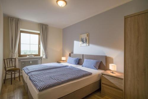 Un dormitorio con una cama y un escritorio y una ventana. en Bergschlössl - Eckwohnung 24, en Oberaudorf