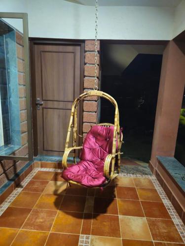 a pink chair sitting on a porch swing at Luxury Konkan Beach Stay Guhagar in Guhagar