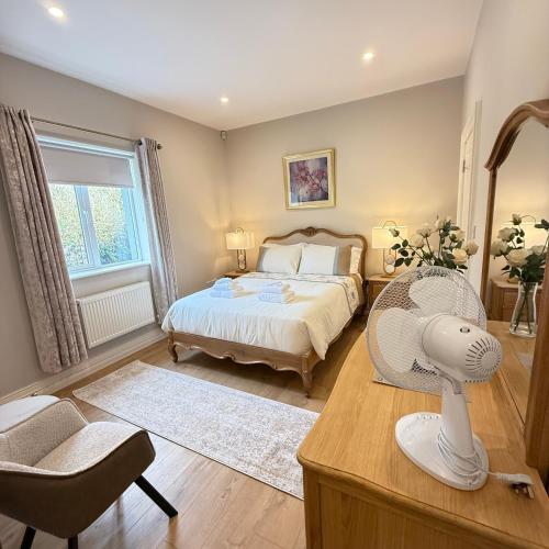 Schlafzimmer mit einem Bett und einem Schreibtisch mit einem Ventilator in der Unterkunft Castle View House - Luxury Vacation Home with Mountain & Sea Views - 5 min walk to Glenbeigh Village - 10 min drive to Rossbeigh Beach & Dooks Golf Course - On the Ring of Kerry-Wild Atlantic Way - 30 minute drive from Muckross House and National Park in Glenbeigh