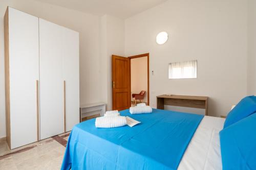 a bedroom with a blue bed and a desk at Villa Bonaria Vacation Home in Capoterra