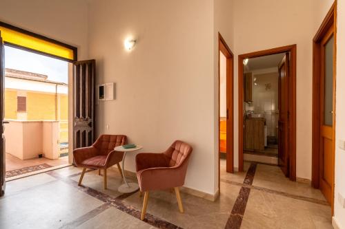 a living room with two chairs and a table at Villa Bonaria Vacation Home in Capoterra