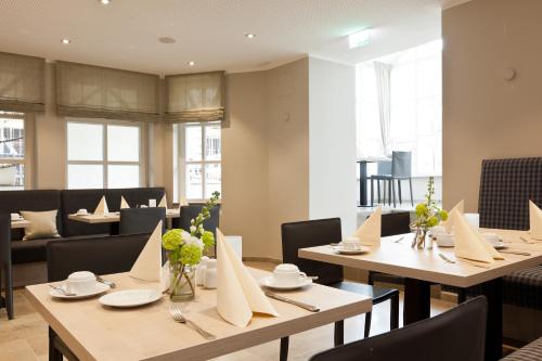 a dining room with wooden tables and chairs at Michels Inselhotel Vier Jahreszeiten in Norderney