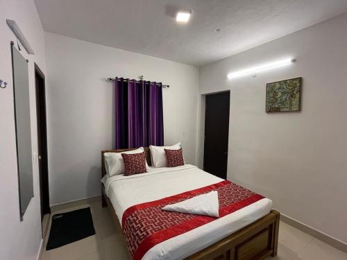 a bed in a room with a purple curtain at BanyanThree in Kodaikānāl