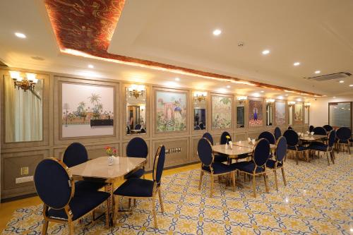 a dining room with tables and chairs and paintings on the walls at Hampton By IC's in Noida