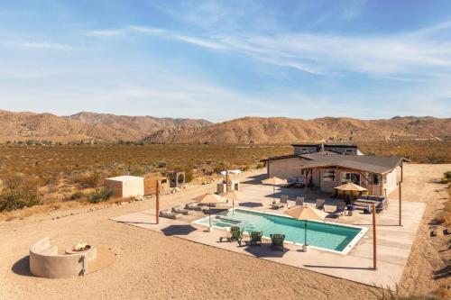a house in the desert with a swimming pool at Hotel California By The Cohost Company in Morongo Valley