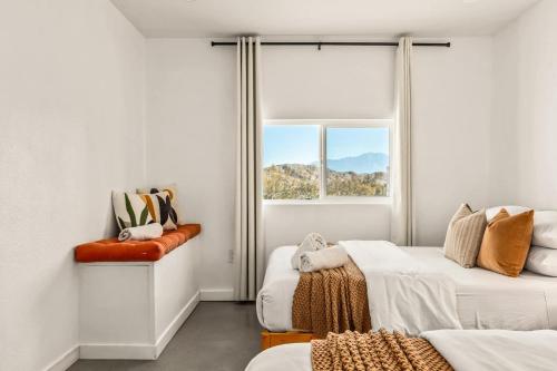 a bedroom with two beds and a window at Hotel California By The Cohost Company in Morongo Valley