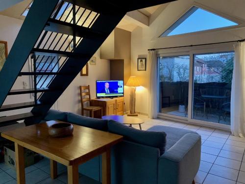 un salon avec un canapé et une télévision dans l'établissement Thonon Concise apt with mezzanine, à Thonon-les-Bains