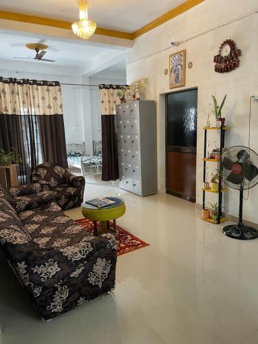 a living room with a couch and a television at Maa Janki Dormitory in Sītāmarhi