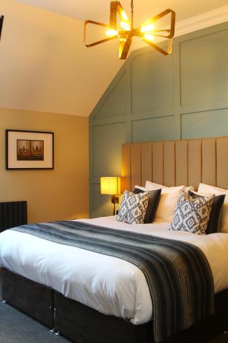 a bedroom with a large bed with a ceiling fan at Coach & Horses Dersingham in Dersingham