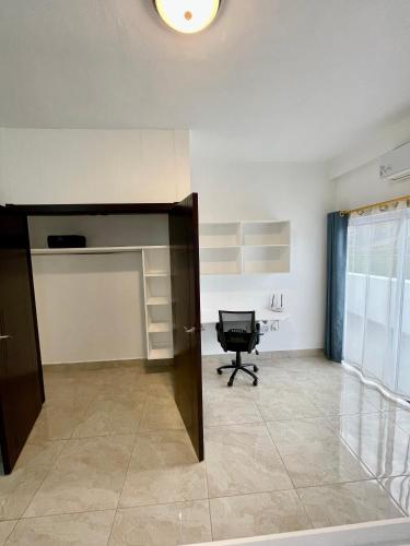 an empty office with a desk and a chair in a room at Blue Star Apartments & Hotel in Lance aux Épines