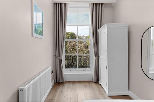 a white room with a large window at Grove Heights Notting Hill in London
