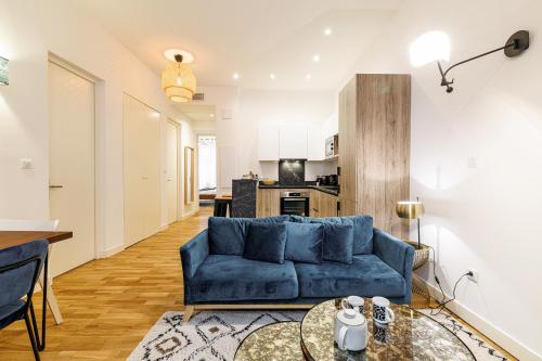 un salon avec un canapé bleu et une table dans l'établissement Chic & Cozy 2 Bdr Heart of the Old Town, à Nice