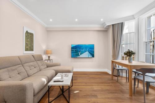 a living room with a couch and a table at Grove Heights Notting Hill in London