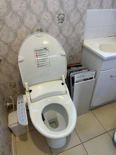 a small bathroom with a toilet with a remote control at sweet house in Auckland