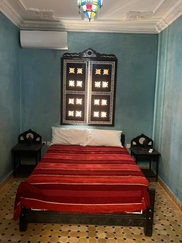 a bedroom with a bed with a red blanket at Bienvenus dans un beau nouveau Riad Tout Entier in Marrakech