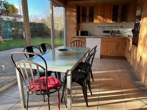 - une table à manger et des chaises dans la cuisine avec une table et des chaises dans l'établissement Maison Trinque Dit, à Audenge