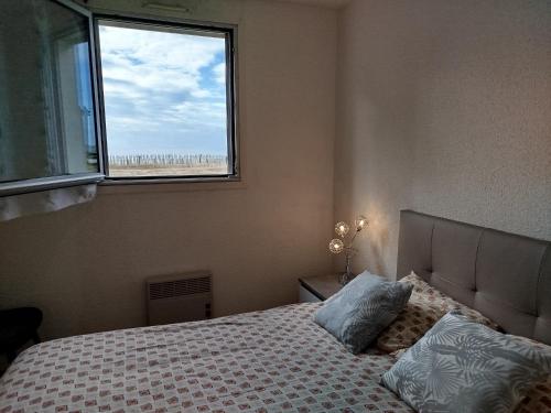 a bedroom with a bed with a view of the beach at les Dunes in Jullouville-les-Pins