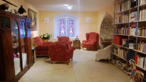 a living room with red chairs and bookshelves at Chambre d'Hotes La Brunetière in Gréoux-les-Bains