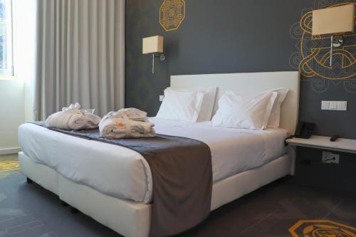 a hotel room with a bed with towels on it at HD | Duecitânia Design Hotel in Penela