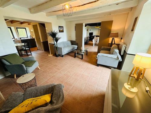 un salon avec des canapés, des chaises et une table dans l'établissement Maison au calme pour 20 personnes, à La Chapelle-de-Brain