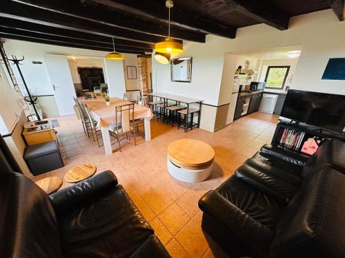 un salon avec une table et une salle à manger dans l'établissement Maison au calme pour 20 personnes, à La Chapelle-de-Brain