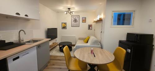 eine Küche und ein Wohnzimmer mit einem Tisch und einer Couch in der Unterkunft Studio 1 in Angoulême