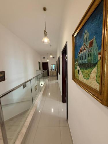 a hallway with a painting of a house on the wall at 4BR Luxury Retreat & Prvt Pool in Sharm