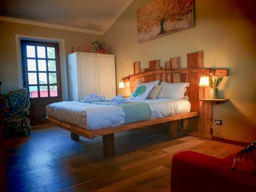 a bedroom with a large bed with a wooden headboard at Agriturismo Podere Orzale Hospitality & Quarter Horses in Usigliano