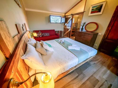 a bedroom with a large bed and a red couch at Agriturismo Podere Orzale Hospitality & Quarter Horses in Usigliano