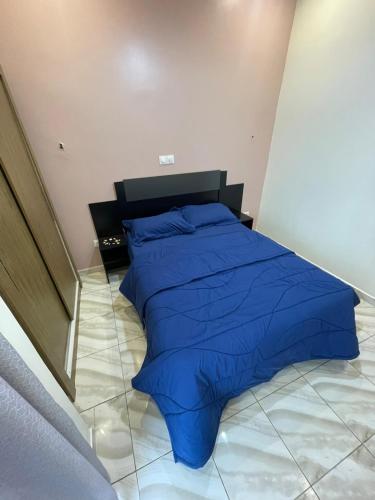 a bed with a blue comforter in a bedroom at Cozy'K Home in Biting