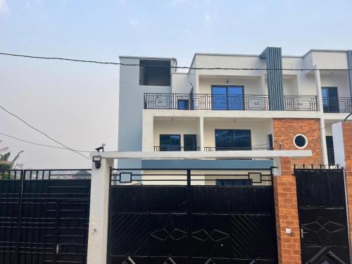 a white house with a black fence and a building at Cozy'K Home in Biting