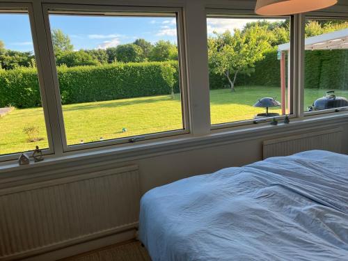 a bedroom with two windows and a bed with a view at House close to city center, beach and Great Northern in Kerteminde