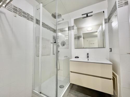 une salle de bain blanche avec une douche et un lavabo dans l'établissement Downtown - Fully equipped studio - Wi-Fi and air conditioning, à Cannes