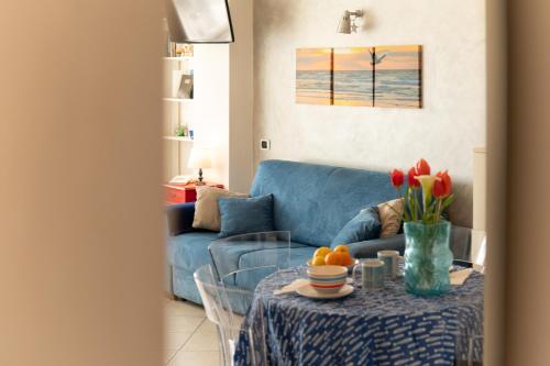 a living room with a blue couch and a table at Sea & Culture in Lerici